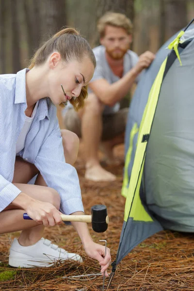 young couple assembling dome tent on camping trip