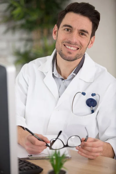 happy male doctor is smiling at the camera