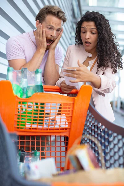 Surprised Young Couple Worried Prices — Stockfoto
