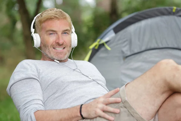 Middle Aged Man Sat Next Tent Wearing Headphones — Stock Photo, Image