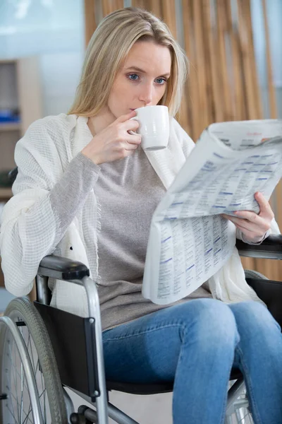 happy disabled woman in wheelchair drinking coffee