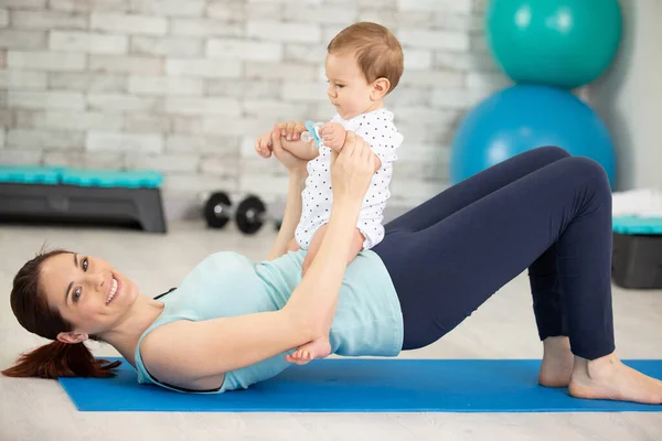mother does physical fitness with her baby