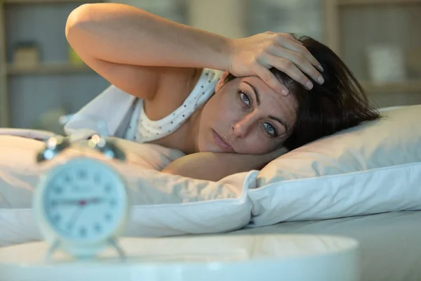 woman lying in bed suffering from insomnia