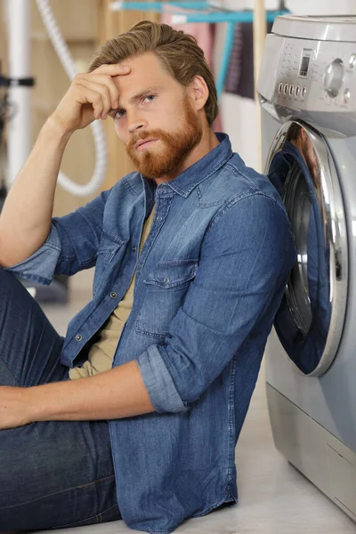 Young Man Sitting Next Washing Machine — Stok fotoğraf