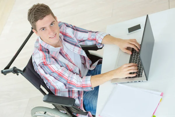 車椅子の男が創造的なオフィスでコンピューターを使って — ストック写真