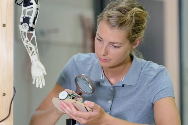 Woman Adjusts Robot Arm Model — Stok fotoğraf