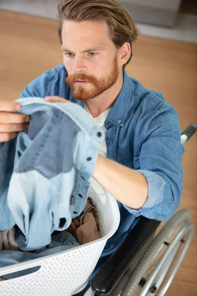 Young Man Wheel Chair Doing Laundry Home — Stockfoto