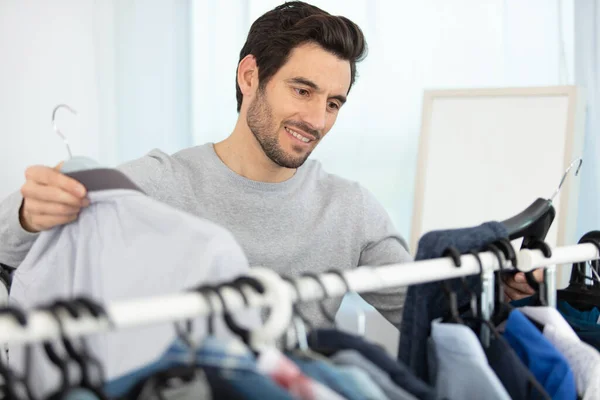 man choosing outfit in wardrobe