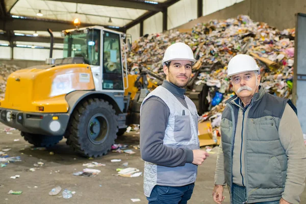 portrait ot two male workers in a recycling center