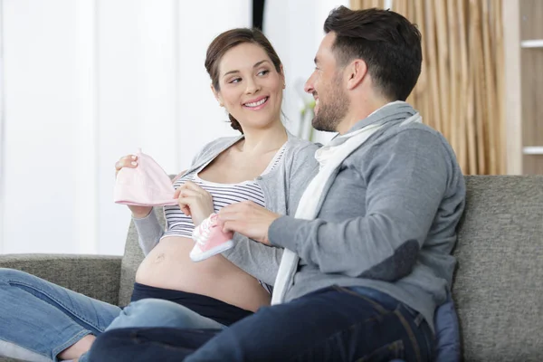 Young Couple Pregnant Woman Holding Children Clothes — Stock Photo, Image