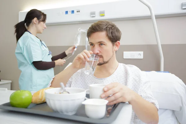 young man patient eating breakfast in hospital