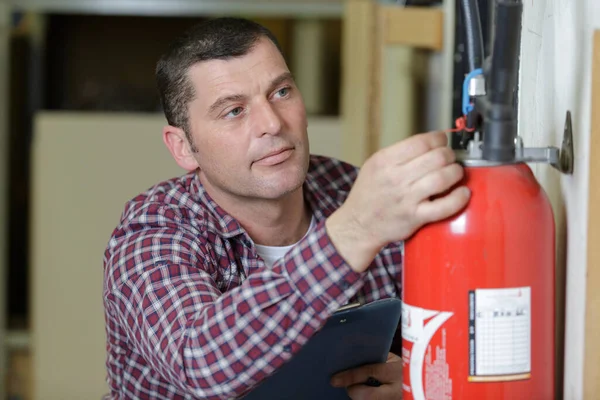 Homem Usando Extintor Contra Fundo Cinza — Fotografia de Stock
