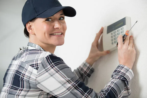 Woman Controls Thermostat — Photo