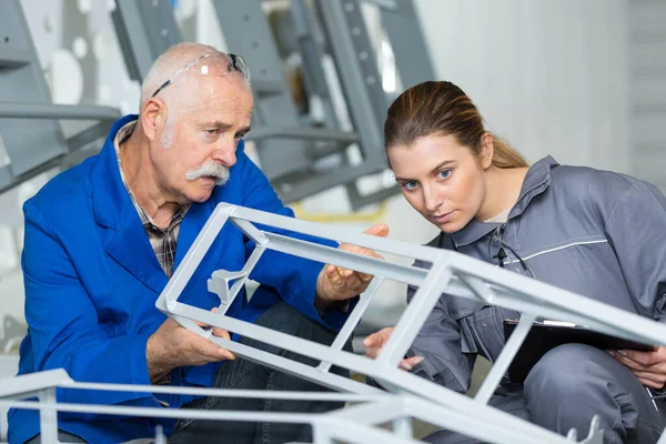 Senior Worker Young Female Colleague Examining Metal Structure — Stockfoto