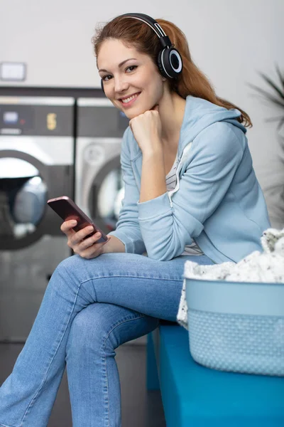 洗濯では携帯電話で待機中の女の子 — ストック写真