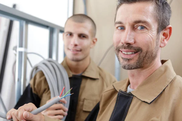 Happy Electrician Holding Corrugated Wire — Stock Photo, Image