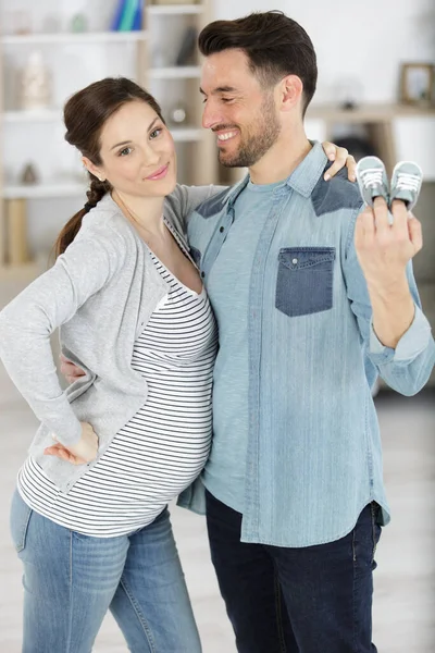 Happy Pregnant Couple Holding Shoes — Stockfoto