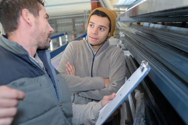 factory worker discussing data with supervisor in metal factory