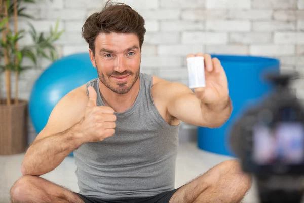 Stilig Manlig Sport Bloggare Hålla Flaska Med Vitaminer — Stockfoto