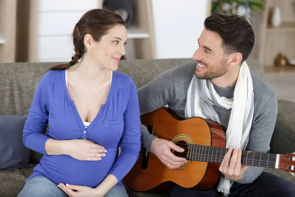 Hombre Practicando Guitarra Con Mujer Embarazada —  Fotos de Stock