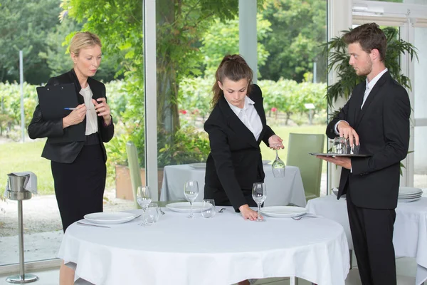 イベントの前にテーブルを用意するウェイターやマネージャーのグループ — ストック写真