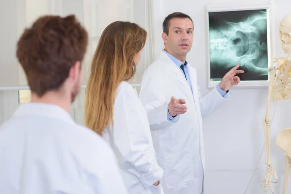 Arzt Mit Kollegen Zeigt Auf Röntgenbild — Stockfoto
