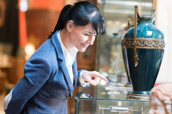 Женщина Смотрит Вазу Своей Коллекции Антиквариата — стоковое фото