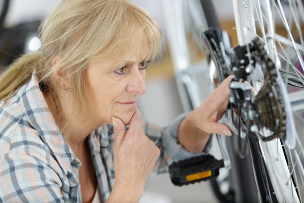 ワークショップで幸せな正の女性修理自転車 — ストック写真
