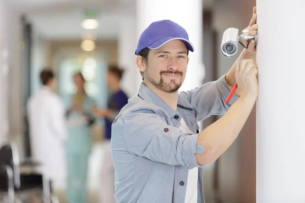 Happy Male Technician Fixing Cctv Camera Hospital — Stock fotografie