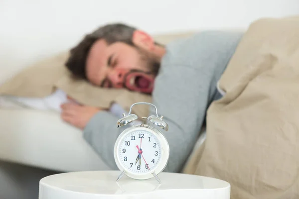 Man Yawning Bed Next Alarm Clock — Stock Photo, Image