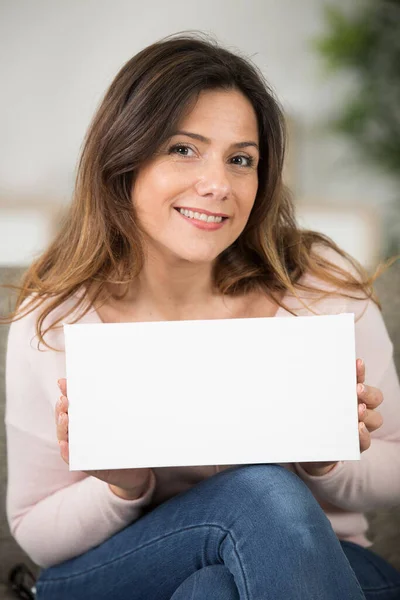 smiling woman holding white board