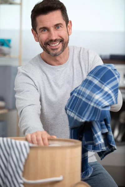 mature man and laundry basket