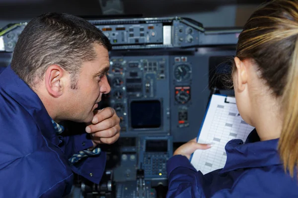 male and female engineers in aircraft cockpit