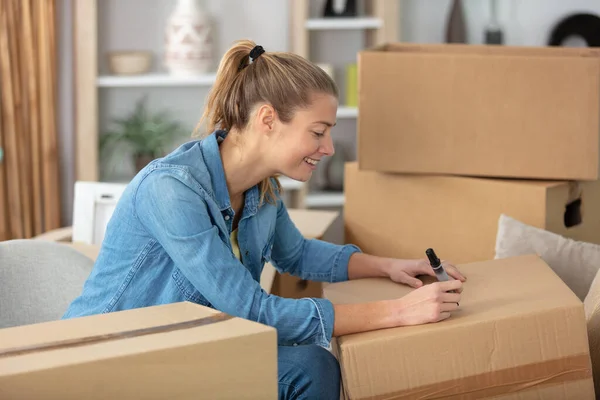 Young Woman Writing Boxes Smiling Relocation — ストック写真