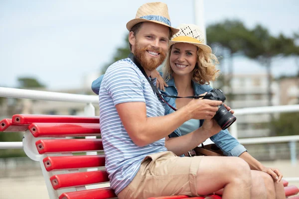 Couple Tourists Reviewing Photos Camera Sitting Bench — Stock Photo, Image