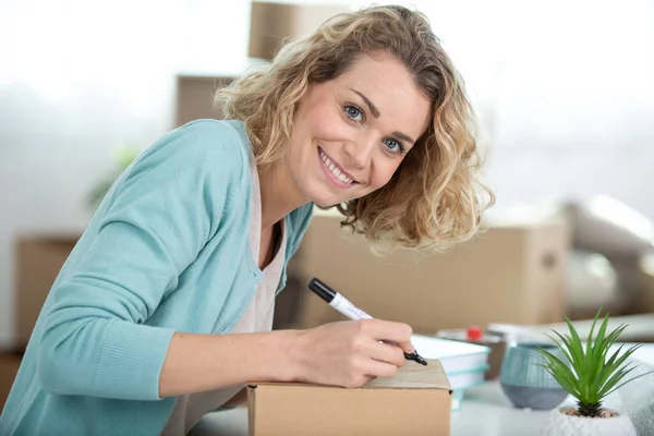 attractive woman signing on delivery paper