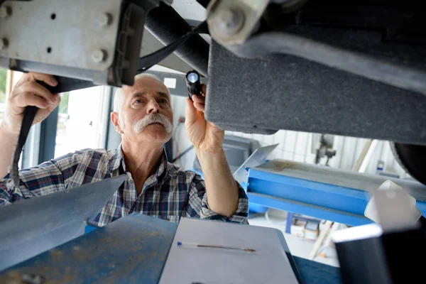 Senior Mechanic Inspecting Leaks — Stockfoto
