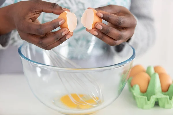 close view of african-american hands breaking egg into bowl