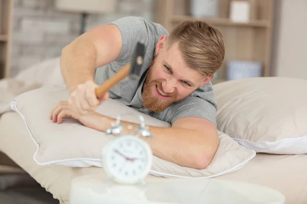 Young Man Tries Break Alarm Clock Hammer — Stock Photo, Image