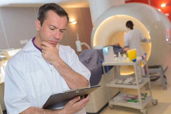 Doctor Reading Clipboard Colleague Preparing Patient — Stock Photo, Image