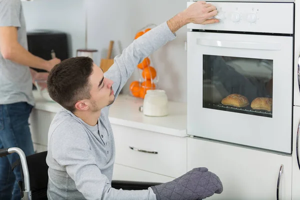 Disabled Young Man Wheelchair Opens Oven — Stock Photo, Image