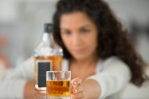 女性を背景にしたアルコールのボトルとガラス — ストック写真
