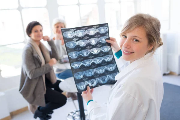 happy young doctor analyzing x-ray