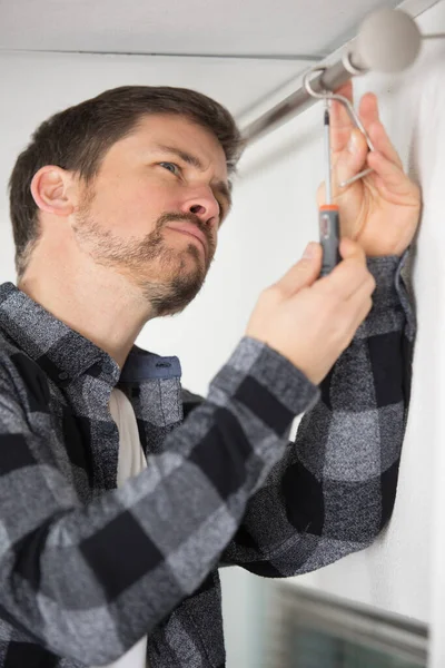 Handsome Man Installing Curtains Home — Stock Photo, Image