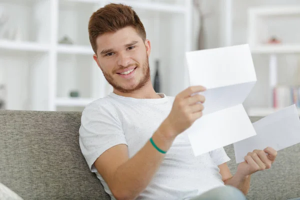 Glücklicher Mann Mit Ein Paar Dokumenten Auf Sofa Wohnzimmer — Stockfoto