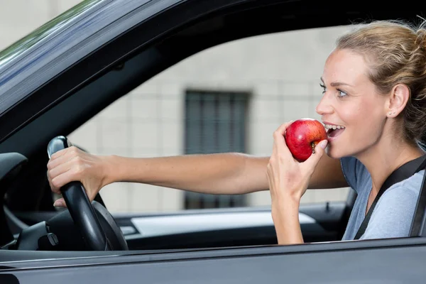 Όμορφη Γυναίκα Τρώει Ένα Μήλο Κατά Την Οδήγηση — Φωτογραφία Αρχείου