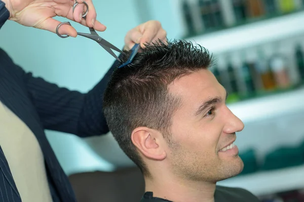 man having his hair cut in a beauty salon