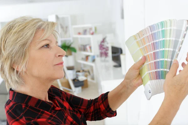 Lycklig Senior Kvinna Välja Färg Från Färgrutor — Stockfoto