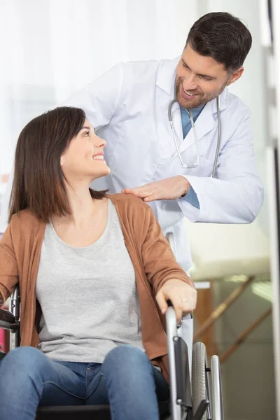 Medico Sorridente Guardando Paziente Una Sedia Rotelle — Foto Stock
