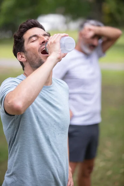 Männer Trinken Wasser Nach Dem Laufen — Stockfoto